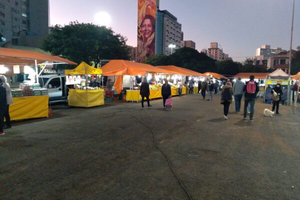 Orange and yellow vendor stalls at an evening street market at Largo da Epatur in Porto Alegre, Brazil