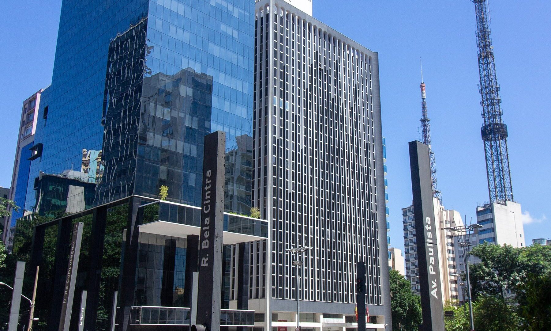 Glass and concrete office towers at the corner of Avenida Paulista and Rua da Consolacao in Sao Paulo under a blue sky