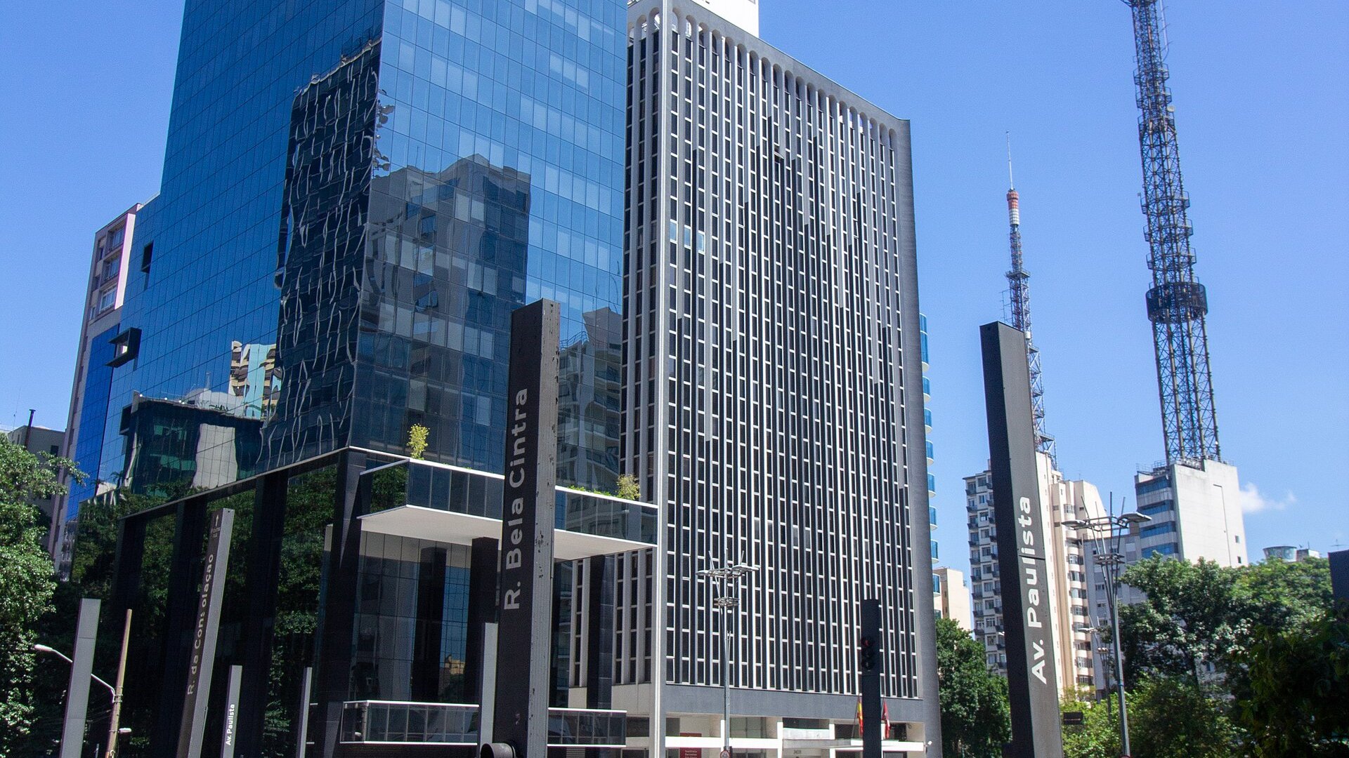 Glass and concrete office towers at the corner of Avenida Paulista and Rua da Consolacao in Sao Paulo under a blue sky