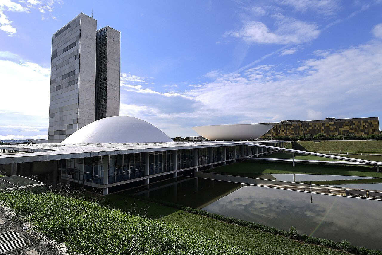 Brazil's National Congress in Brasília, with the Senate dome, the twin towers and the bowl of the Chamber of Deputies beside a reflecting pool