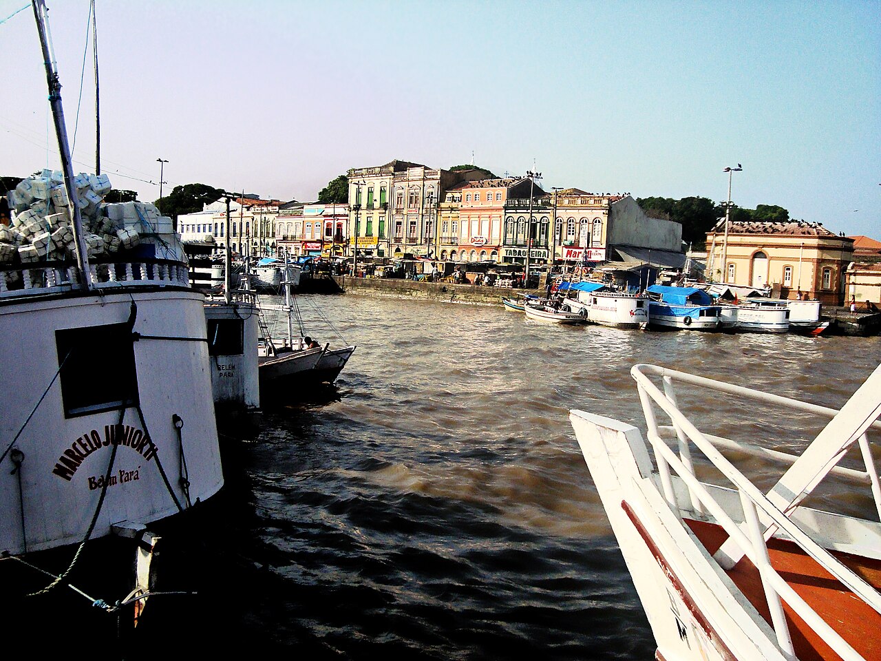 River boats moored at the Ver-o-Peso waterfront in Belém, with a row of colourful old buildings along the quay behind them