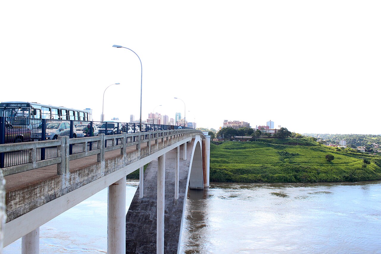 The Friendship Bridge over the Paraná River, with a Ciudad del Este bus and cars on the deck and buildings on the far bank