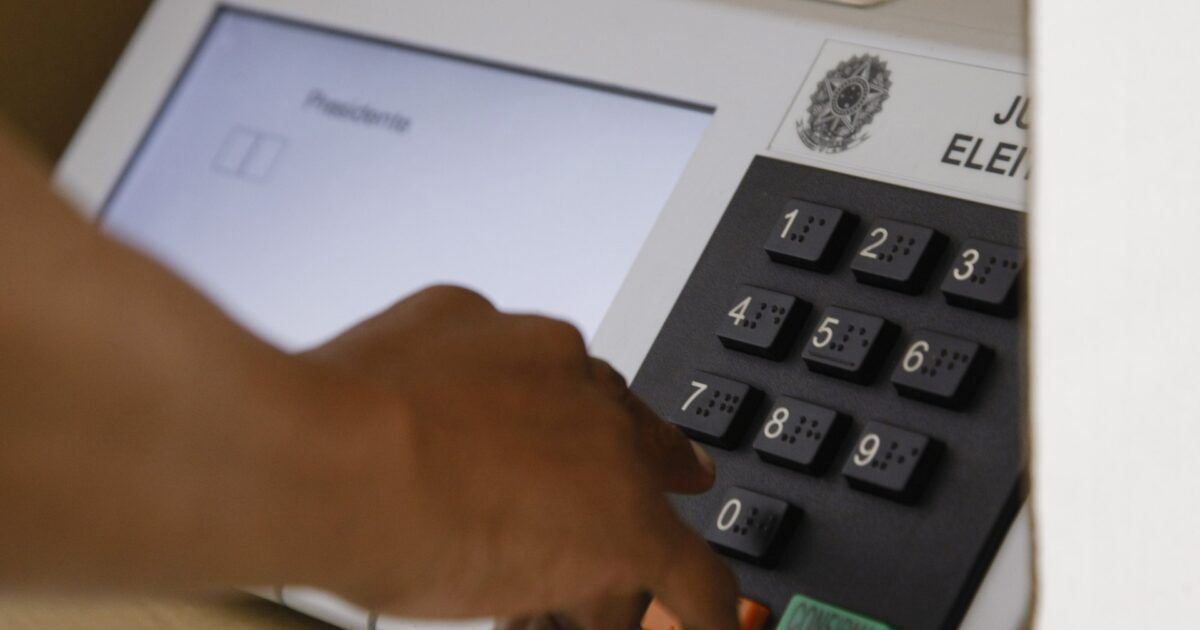 A voter presses the keys of a Brazilian electronic voting machine showing the presidential ballot