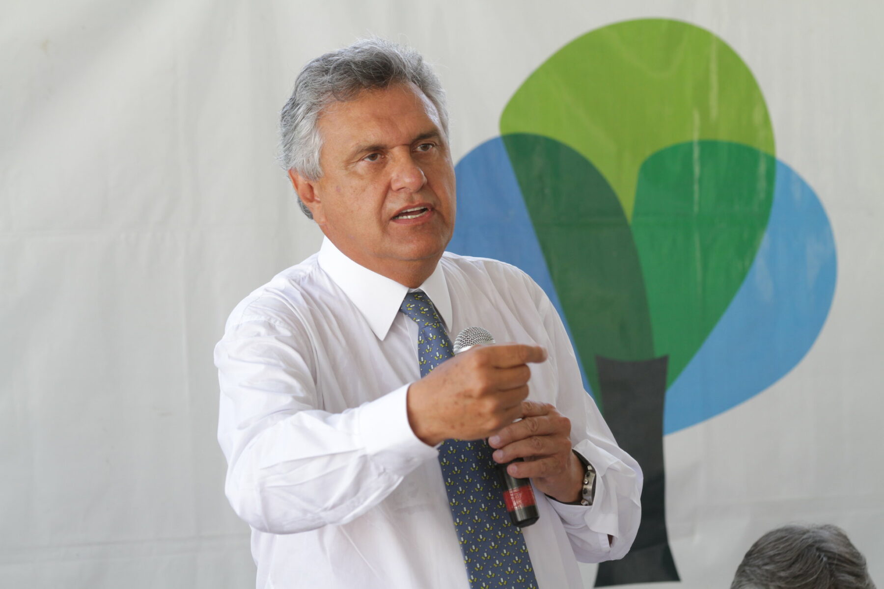 Ronaldo Caiado speaking into a microphone at a party meeting in Goiás
