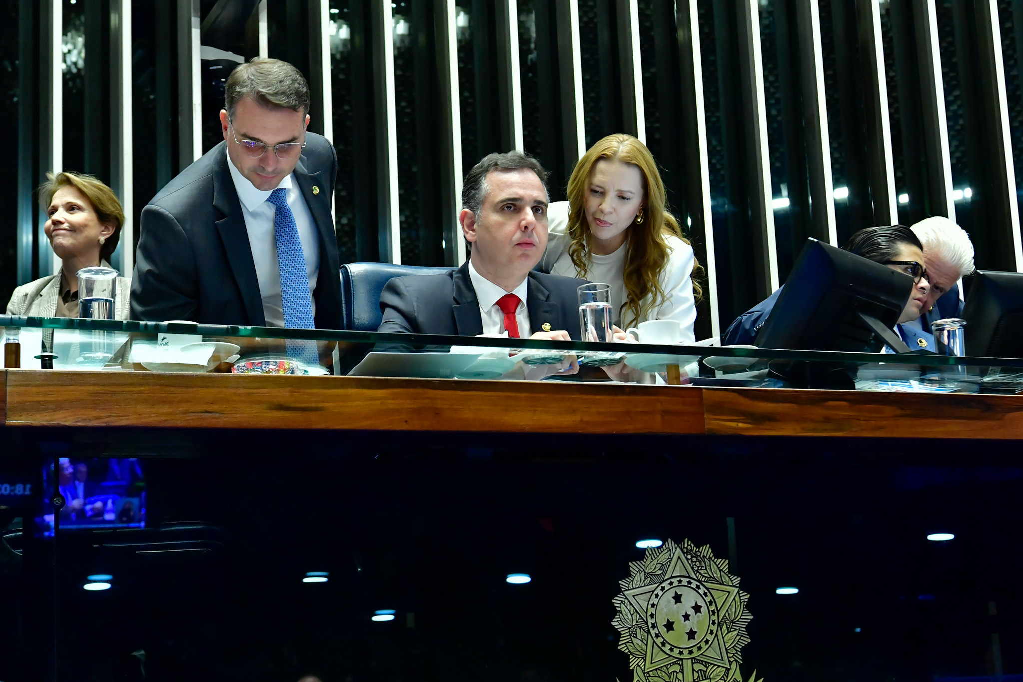 Flávio Bolsonaro standing at the Senate presiding table beside then Senate president Rodrigo Pacheco