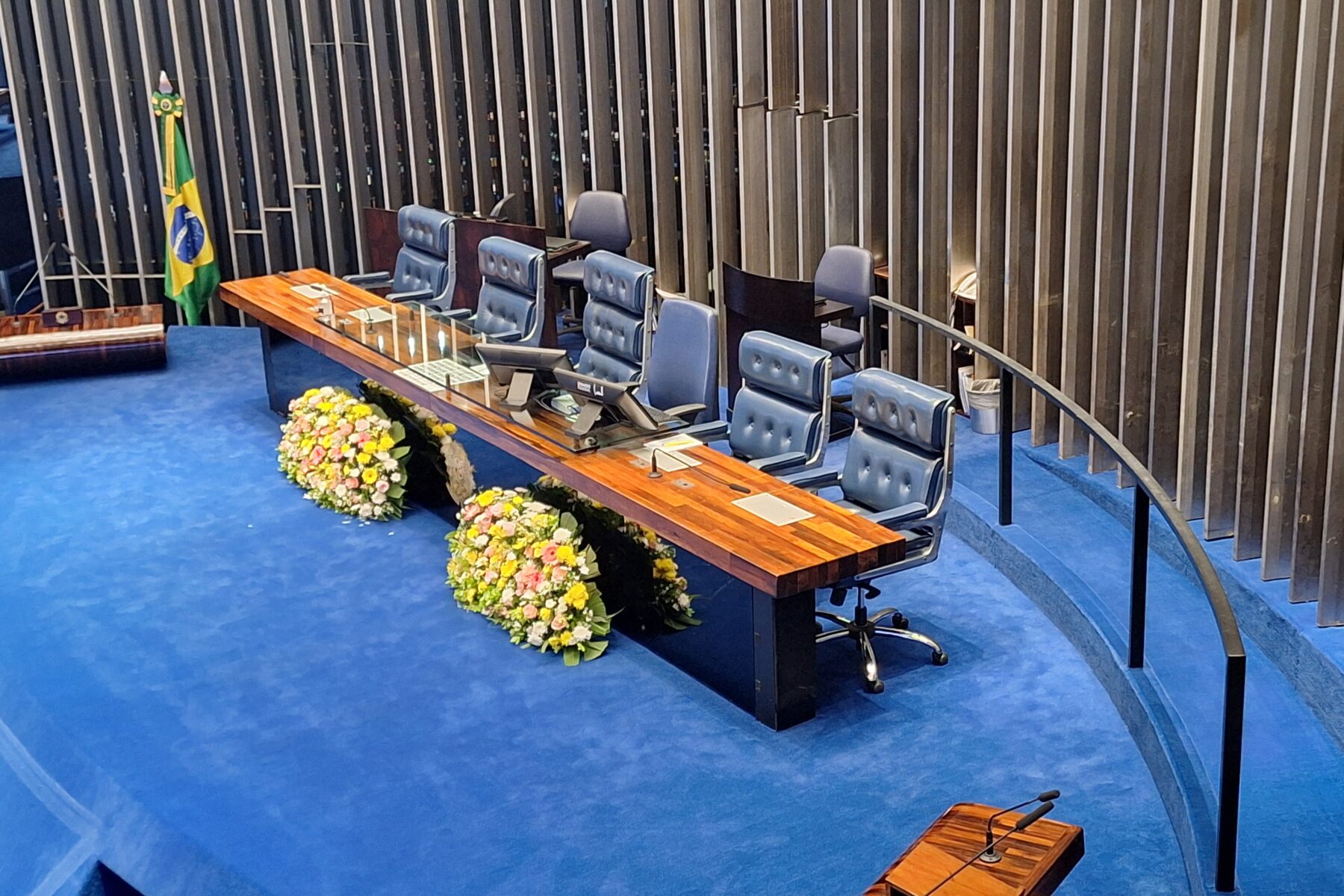 The presiding table and podium of the Federal Senate plenary in Brasília, with the Brazilian flag at left