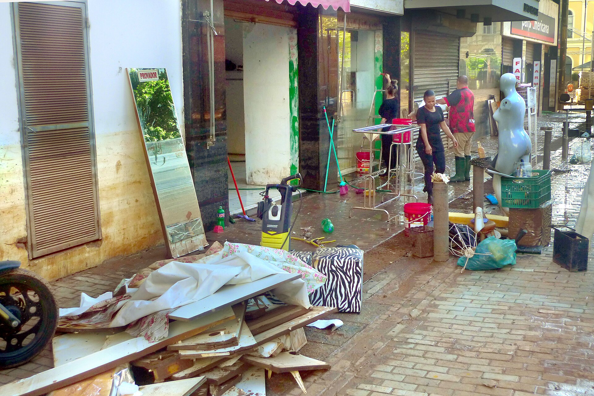 Shopkeepers in Porto Alegre historic centre clearing flood-damaged goods in May 2024