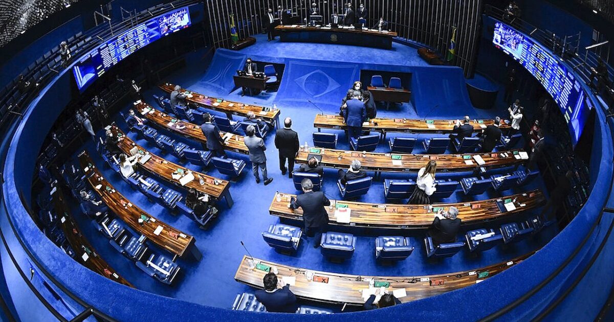 Wide fisheye view of senators at their desks in the blue plenary chamber of Brazil's Federal Senate