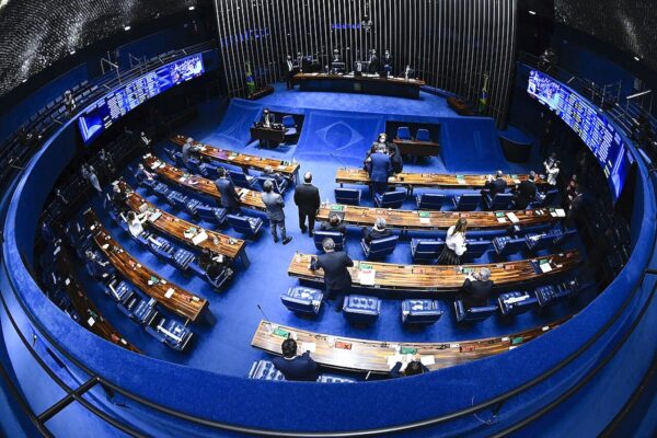 Wide fisheye view of senators at their desks in the blue plenary chamber of Brazil's Federal Senate