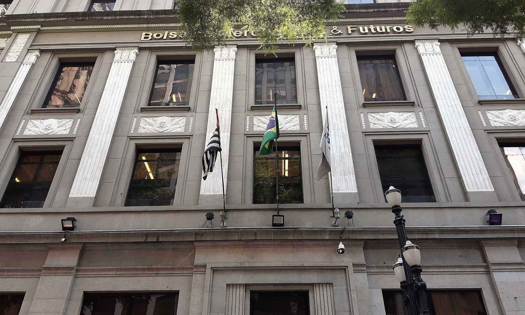 Facade of the former Bolsa de Mercadorias & Futuros building in downtown São Paulo with Brazilian, São Paulo state and B3 flags