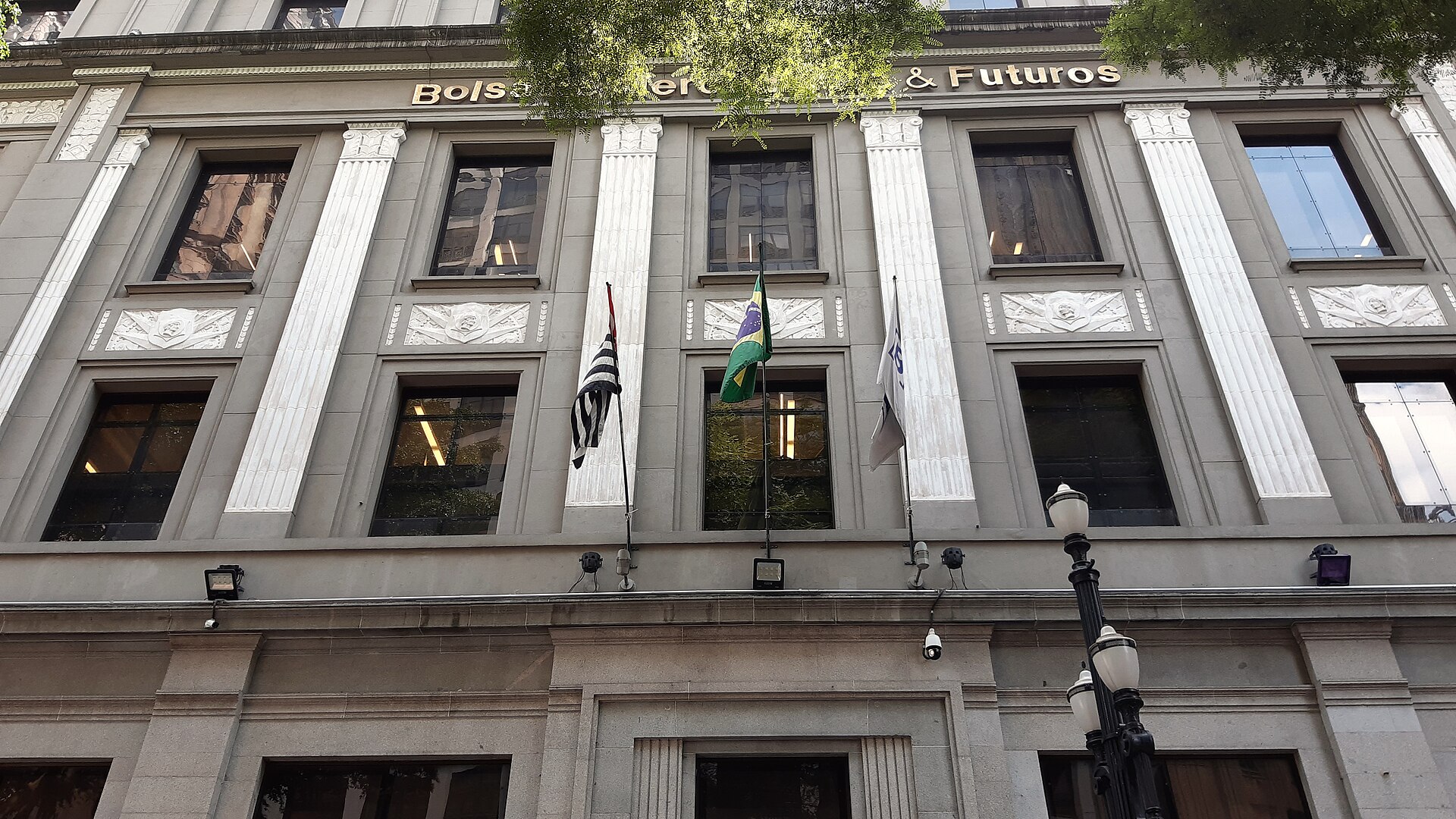 Facade of the former Bolsa de Mercadorias & Futuros building in downtown São Paulo with Brazilian, São Paulo state and B3 flags