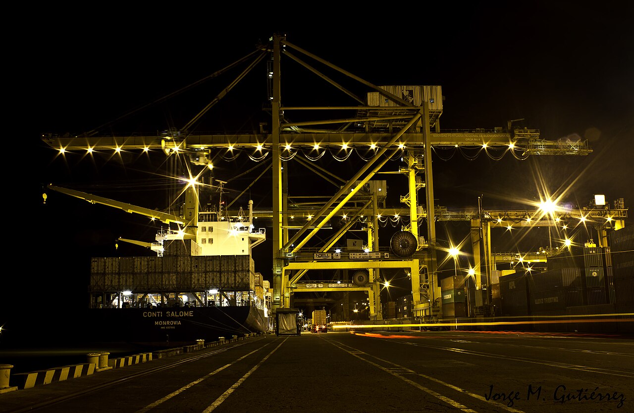 Container cranes unloading a cargo ship at night at the Sociedad Portuaria Regional de Buenaventura, Colombia