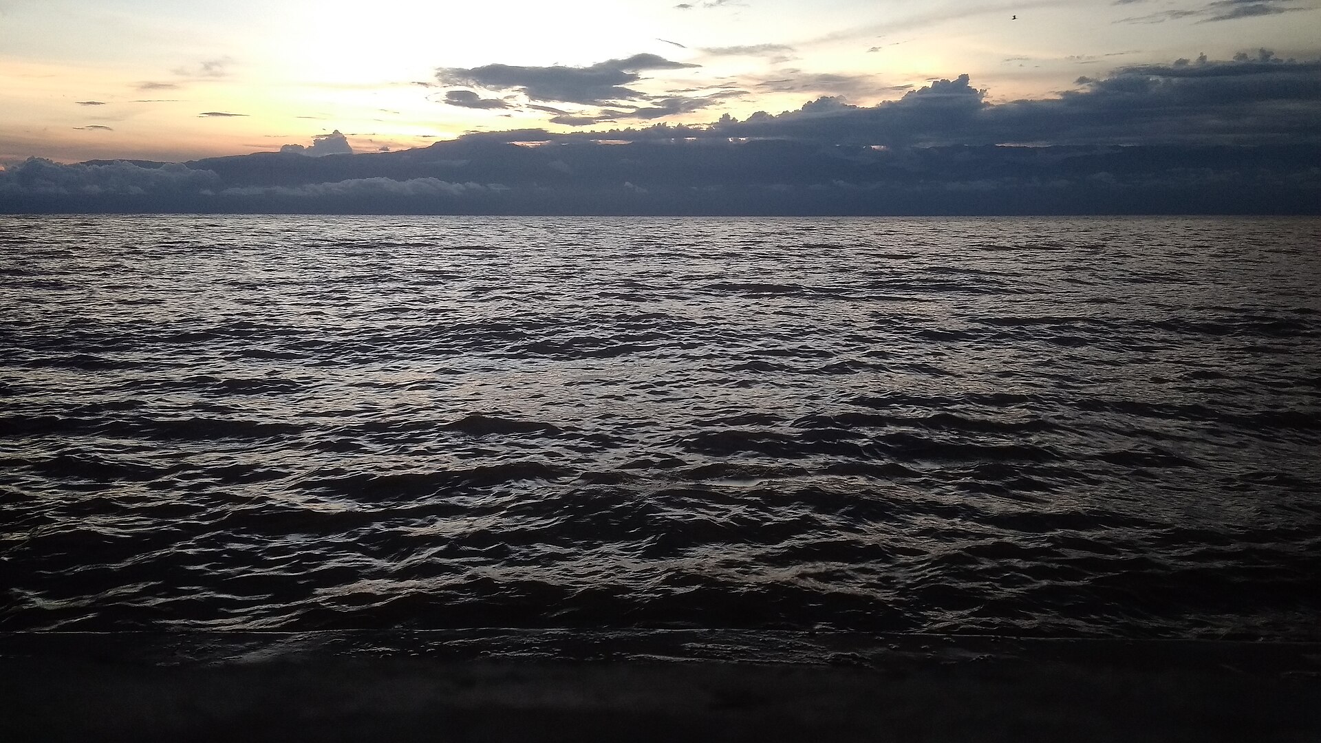 Dusk over Lake Tanganyika seen from Bujumbura, with the hills on the Congolese side of the lake along the horizon.