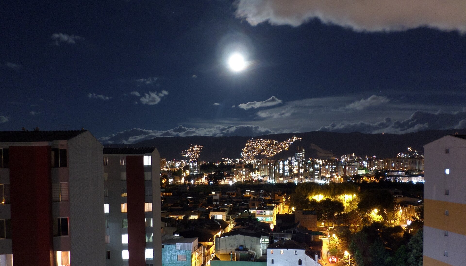 Northern Bogotá at night under a full moon, with the eastern hills behind