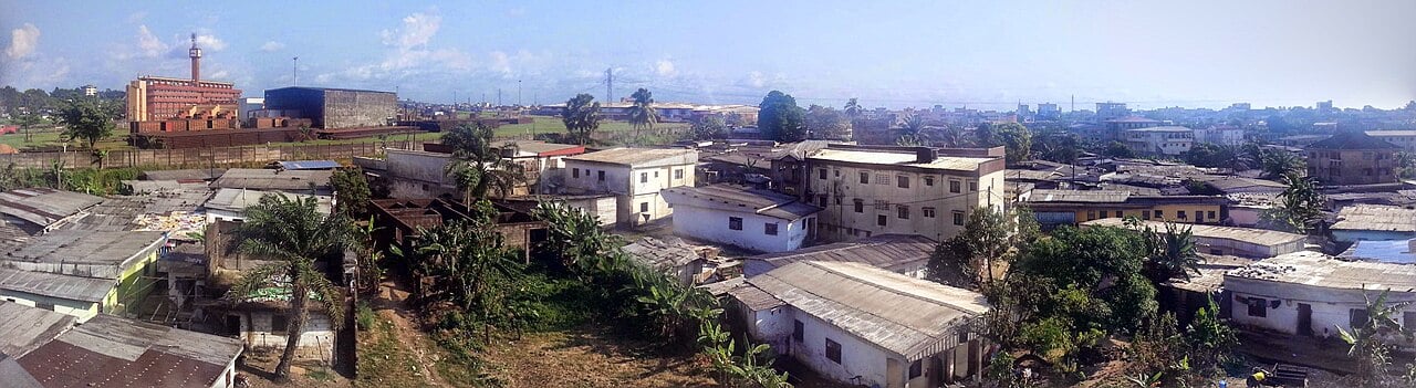 Panorama of Douala, Cameroon's largest city and business centre, with low-rise houses and a factory building on the left