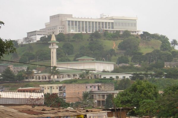 The Palais des Congrès on a hill in Yaoundé, Cameroon, with the Briqueterie mosque below it