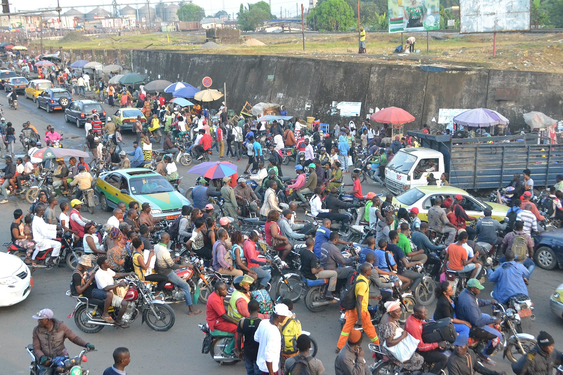 Crowd of motorbike taxis, cars and pedestrians packing the Ndokoti junction in Douala, Cameroon