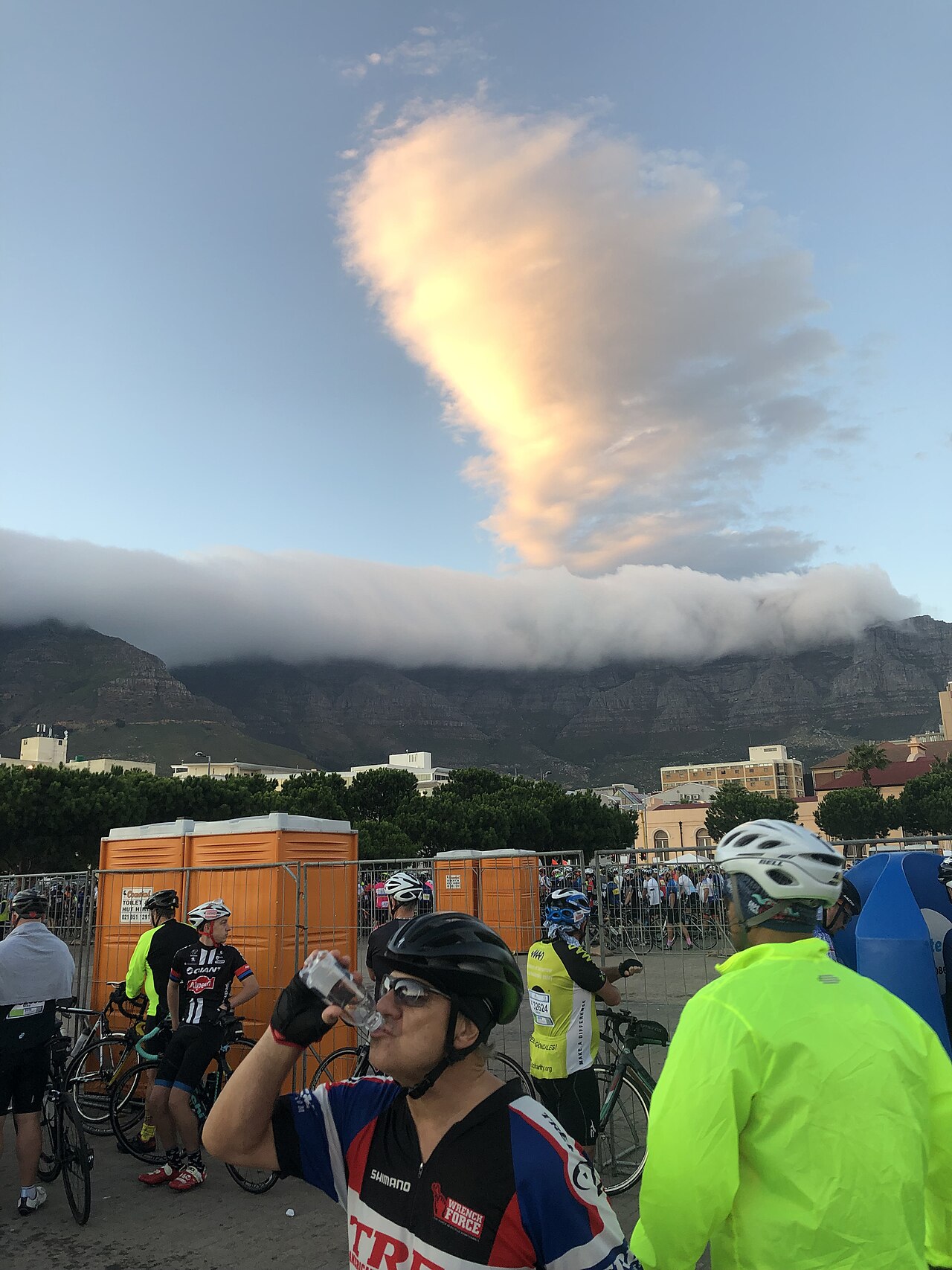 Cyclists waiting at the Cape Town Cycle Tour start with Table Mountain and its cloud cap behind them.