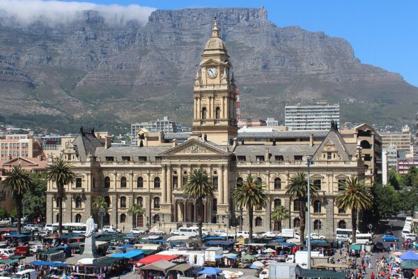 Cape Town City Hall with Table Mountain behind it and street stalls on the Grand Parade in the foreground.
