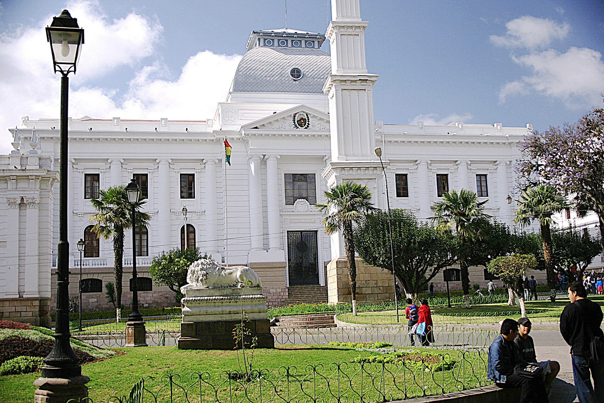 White neoclassical government palace with a dome, a tower and a stone lion statue in Sucre, Bolivia