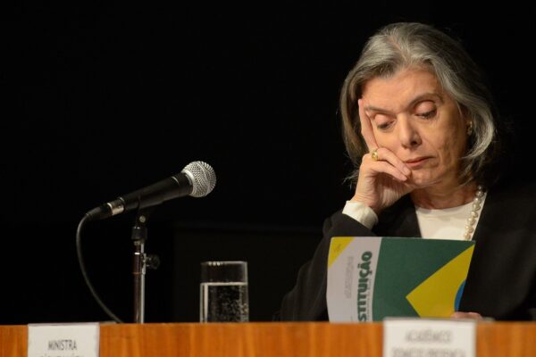 Justice Cármen Lúcia of Brazil's Supreme Court seated at a microphone, resting her face on her hand
