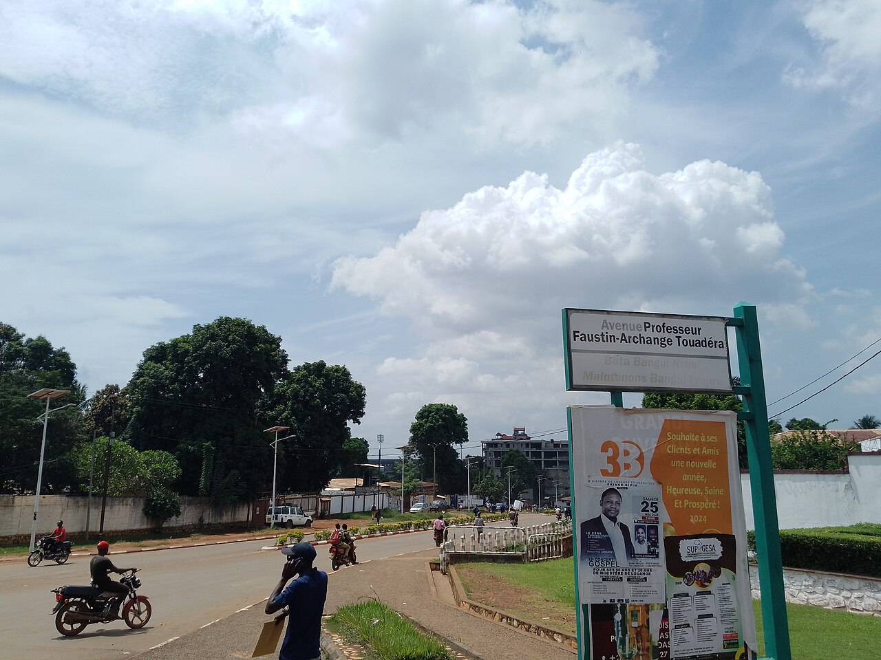 Motorcycle taxis on Avenue Professeur Faustin-Archange Touadéra in Bangui, Central African Republic, under a cloudy sky