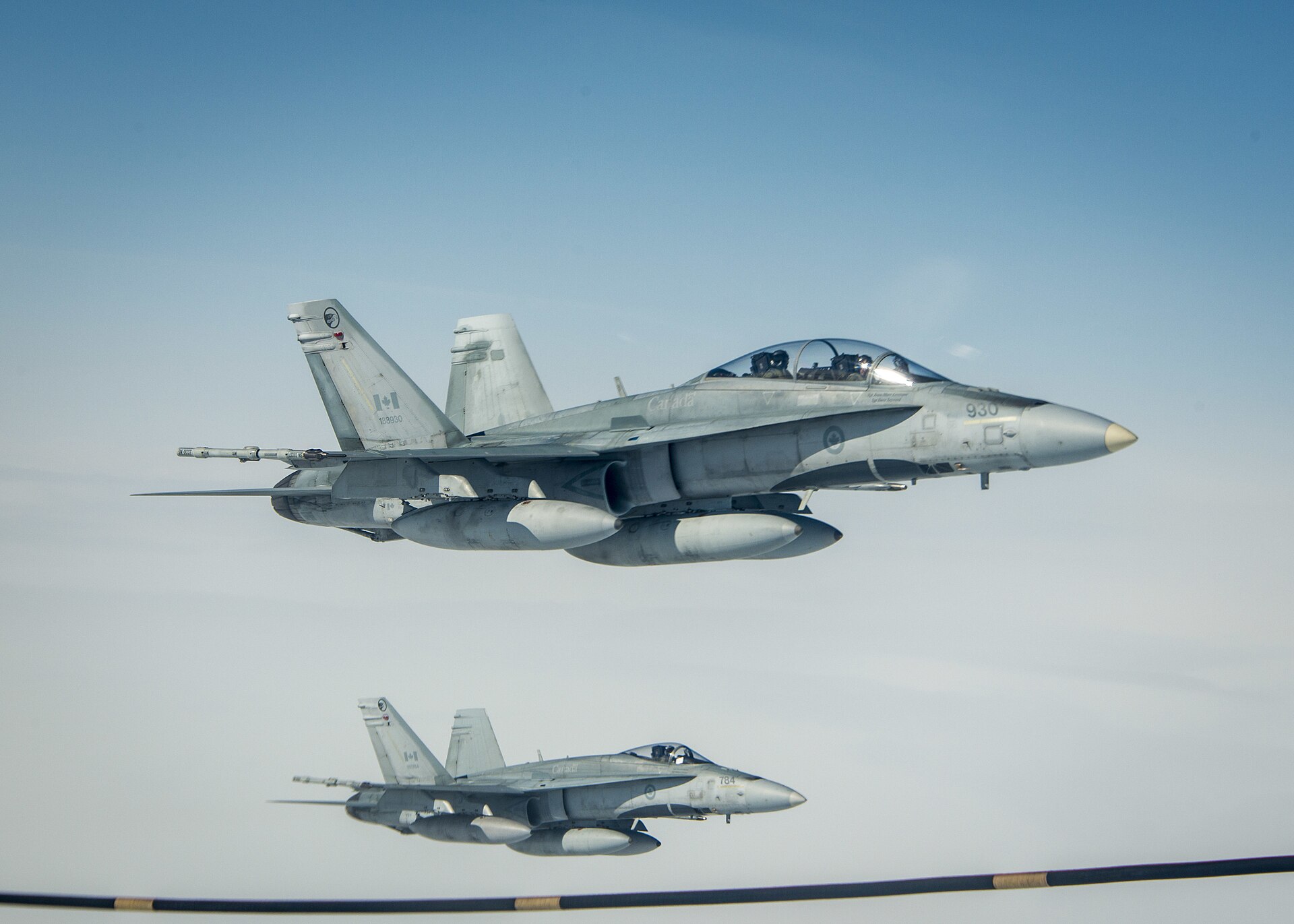 Two Royal Canadian Air Force CF-18 Hornet fighter jets flying in formation.