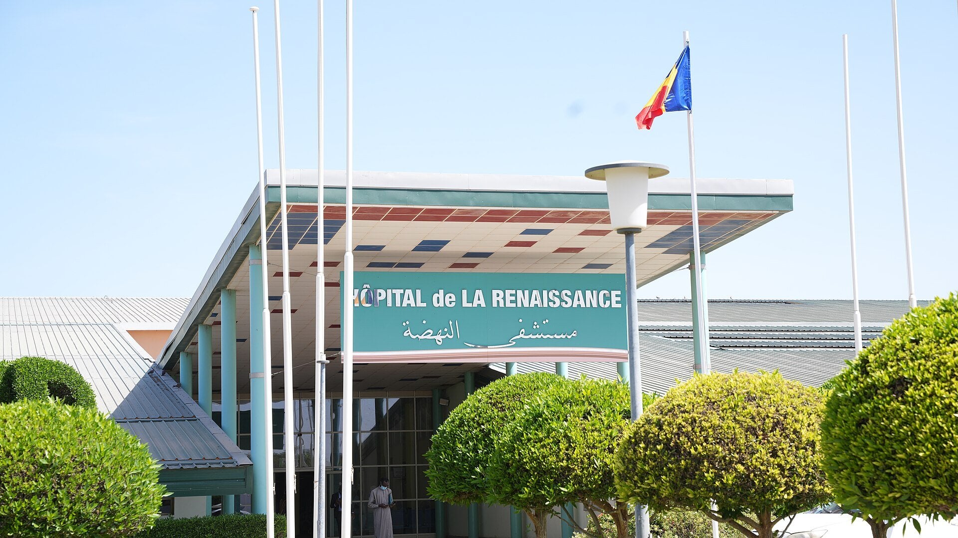 Entrance canopy and sign of the Renaissance Hospital in N'Djamena, Chad, with the Chadian flag