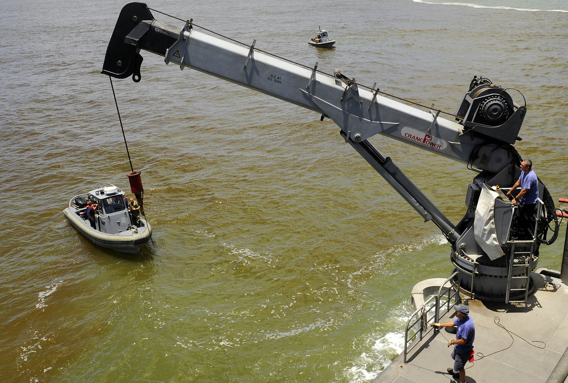 Contractor mariners lower a survey boat into the water in Georgetown, Guyana, to measure the depth of the port