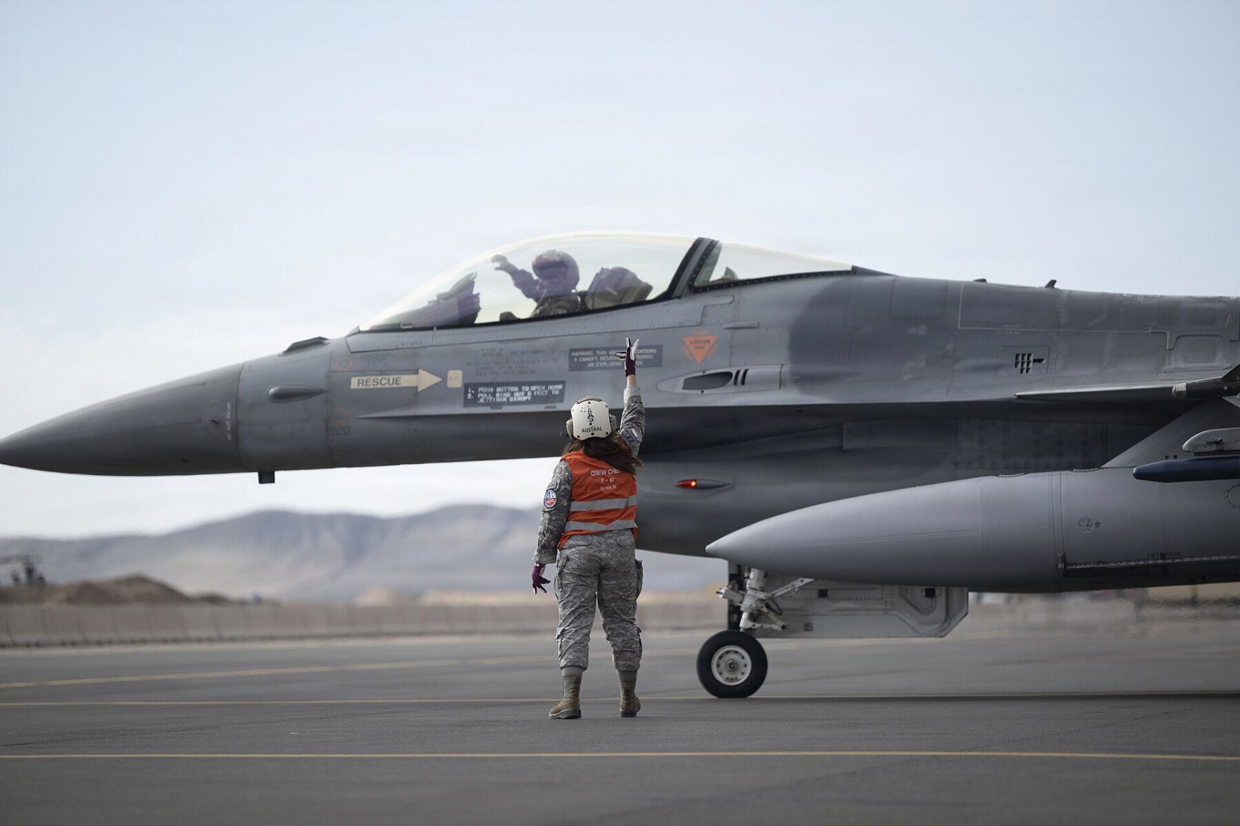 A Chilean Air Force crew chief signals to the pilot of an F-16C fighter on the ramp at Cerro Moreno Air Base in Antofagasta