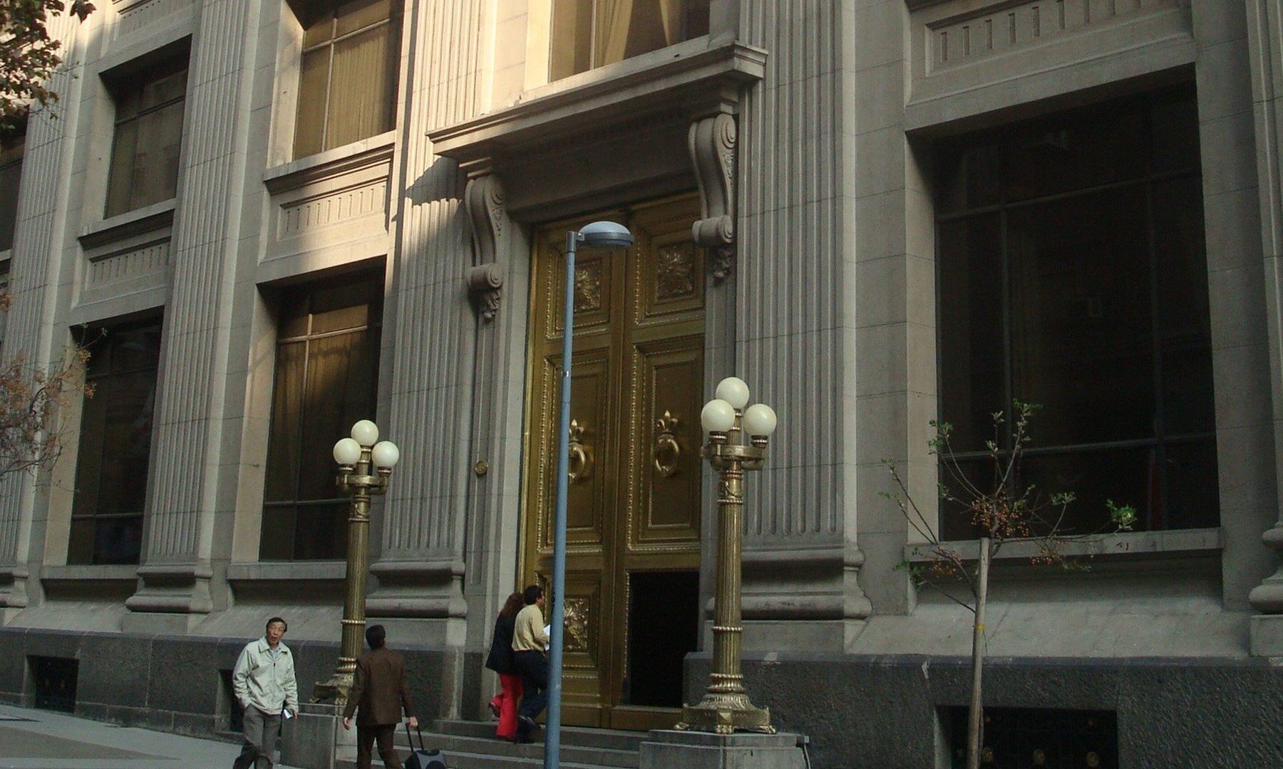 Golden doors and lamp posts at the street entrance of the Banco Central de Chile building in Santiago