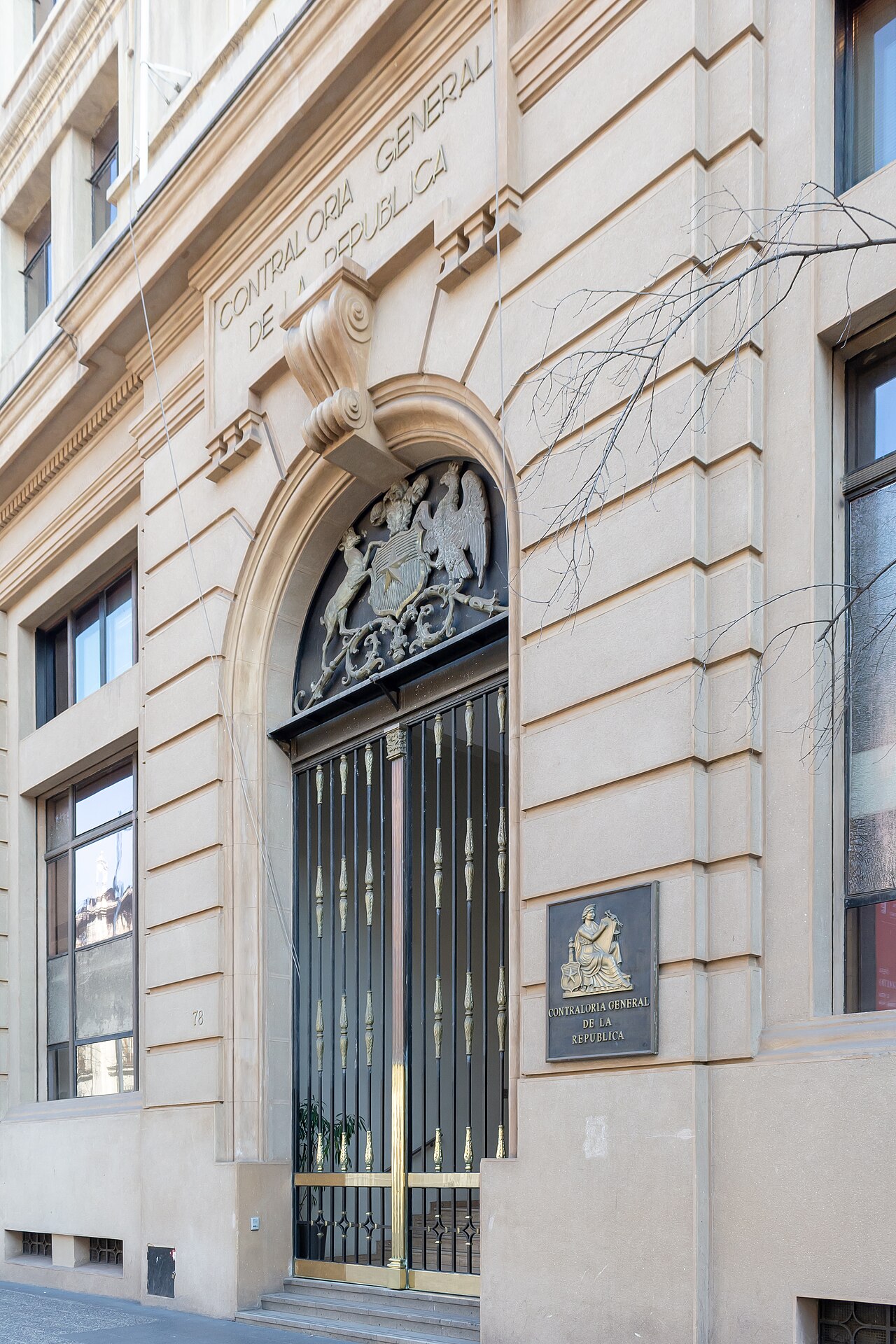Stone entrance of the Contraloría General de la República building in Santiago, with the Chilean coat of arms above an iron gate
