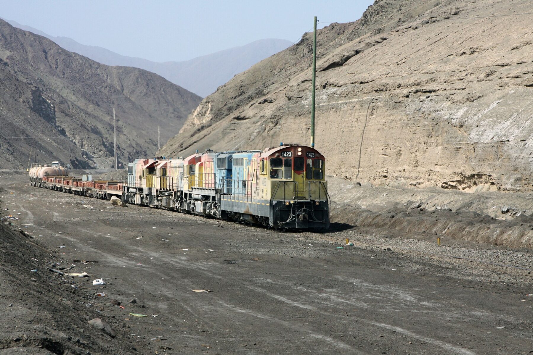 A freight train carries stacked copper plates through a desert valley in northern Chile