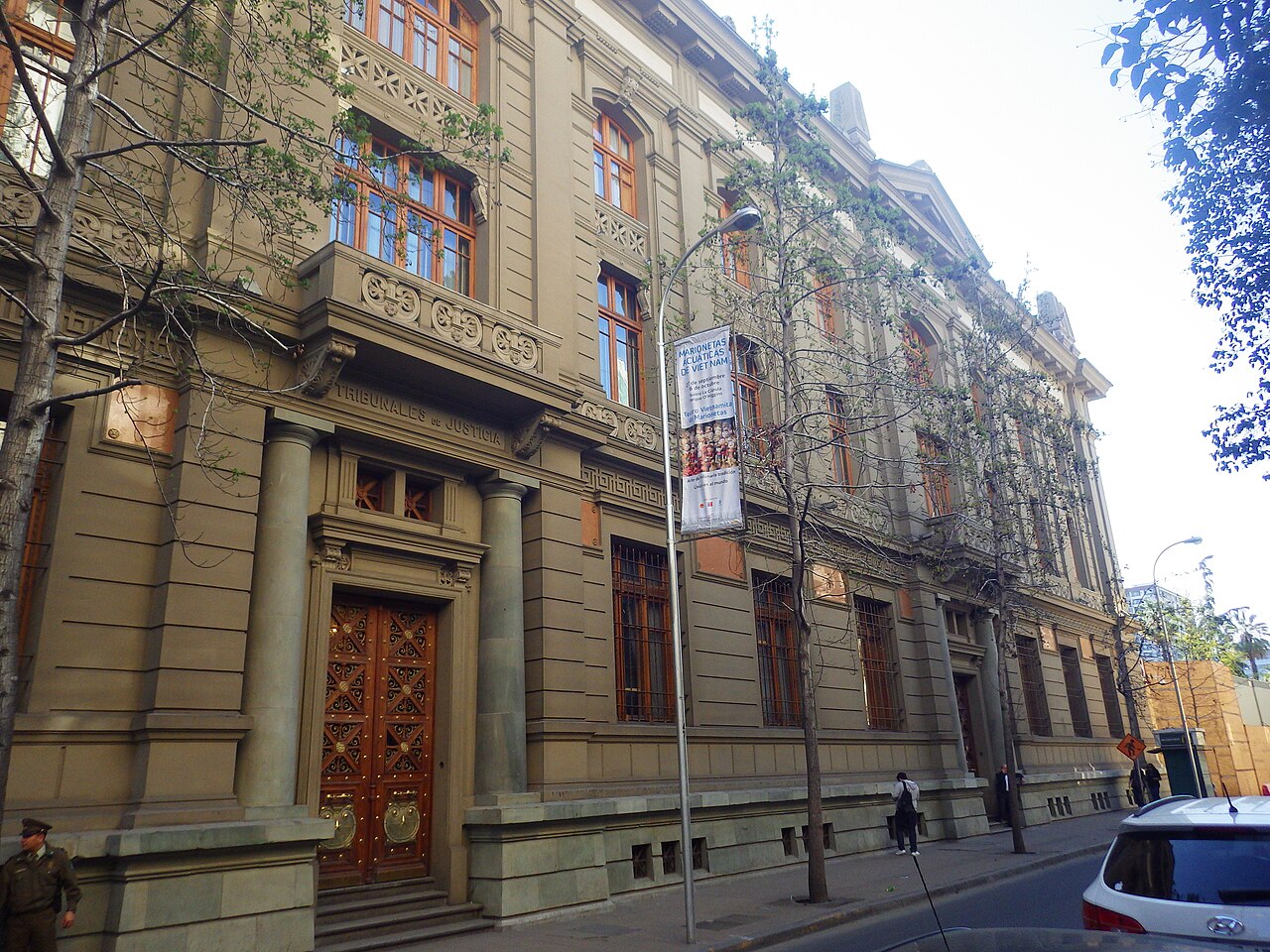 A side entrance of the Palace of Courts in Santiago, Chile, with carved wooden doors and the words Tribunales de Justicia above