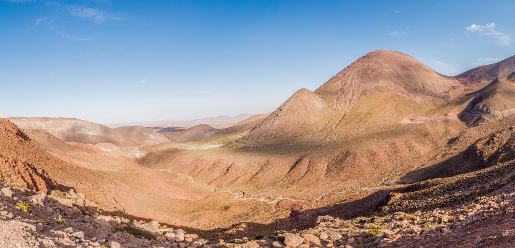 Wide view of brown and red desert hills under a blue sky near Calama in northern Chile