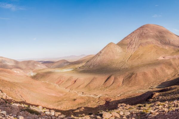 Wide view of brown and red desert hills under a blue sky near Calama in northern Chile