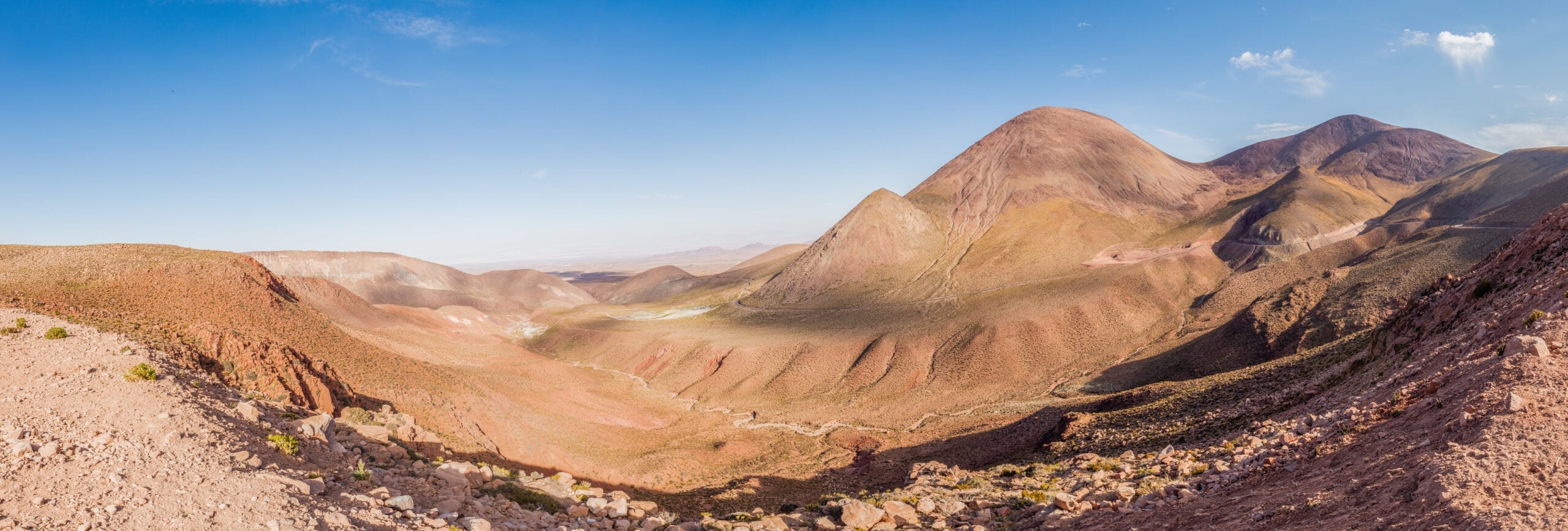 Wide view of brown and red desert hills under a blue sky near Calama in northern Chile