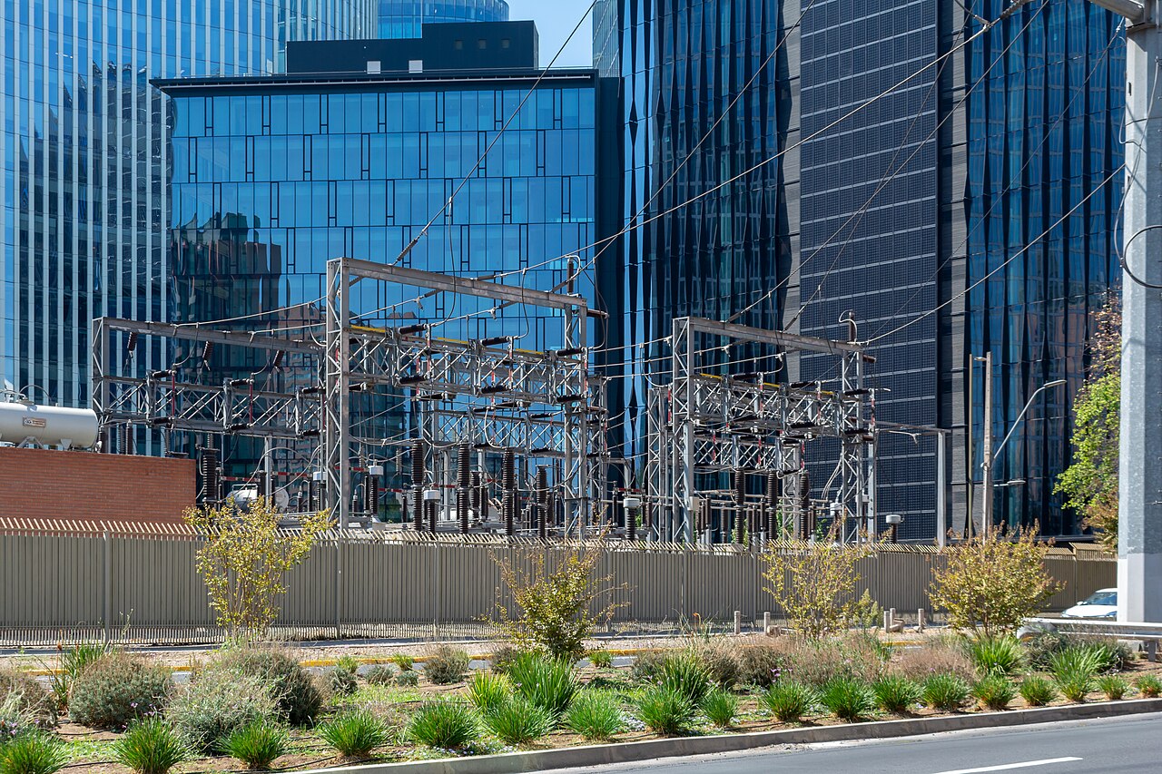 Electrical substation equipment in front of glass office towers in Santiago, Chile