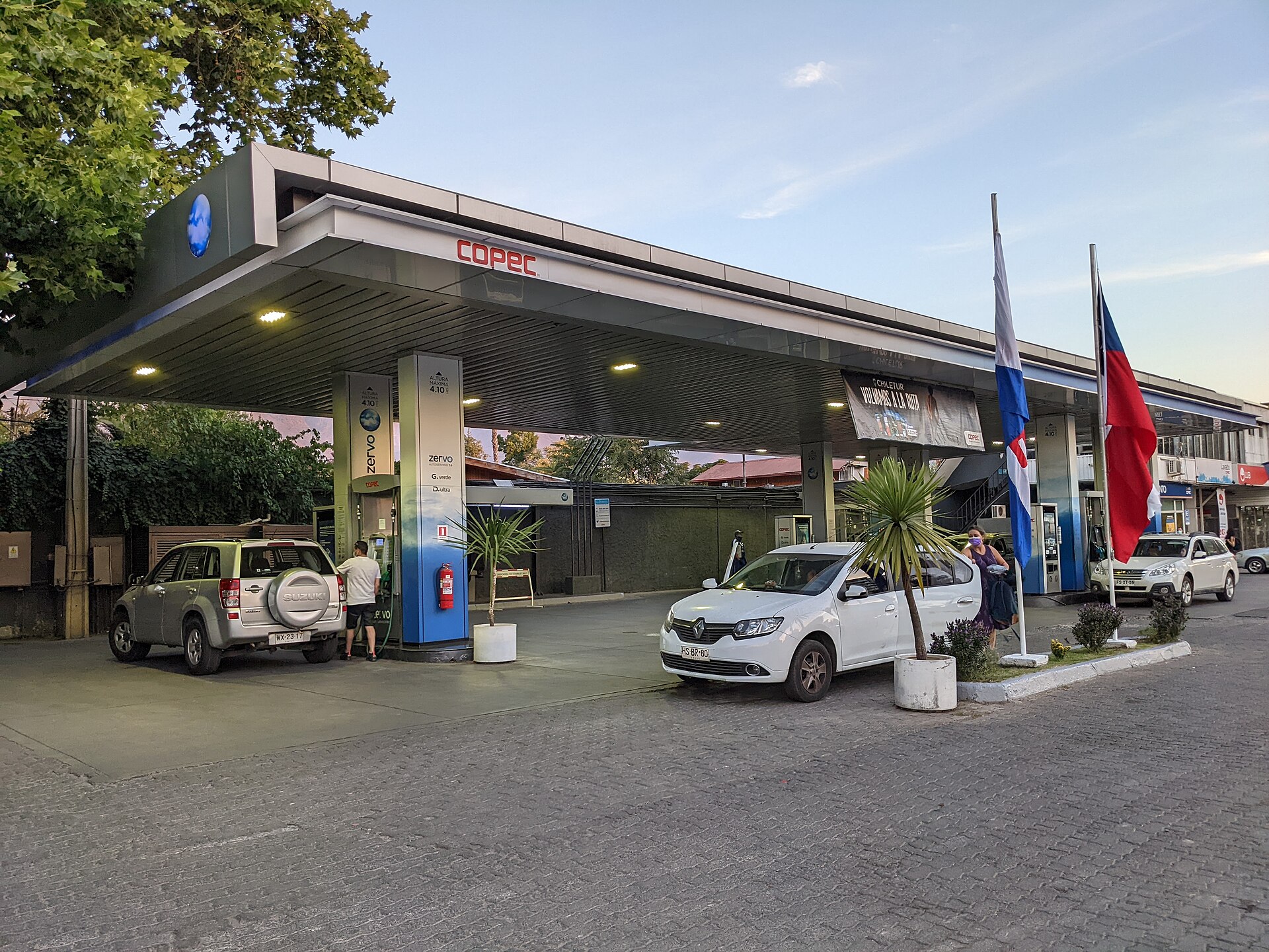 A Copec fuel station with cars and Chilean flags in La Reina, Santiago