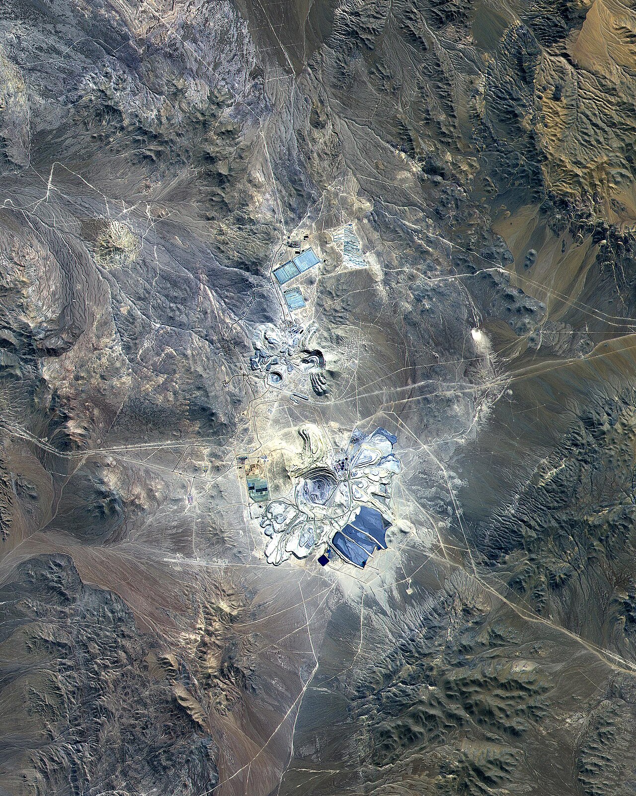Satellite view of the Escondida open-pit copper mine, its tailings and leach pads in the mountains of the Atacama Desert, Chile