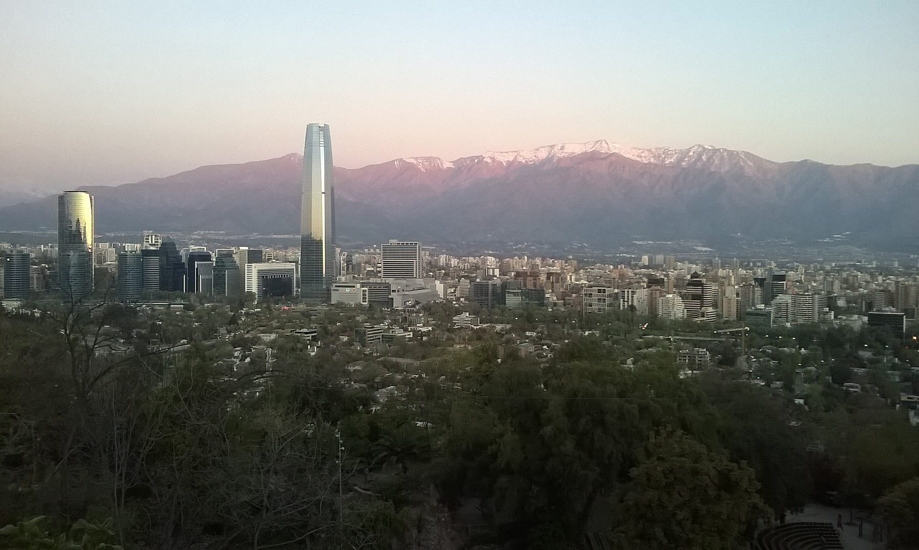 Santiago's financial district and the Gran Torre Santiago at dusk, with the snow-capped Andes behind