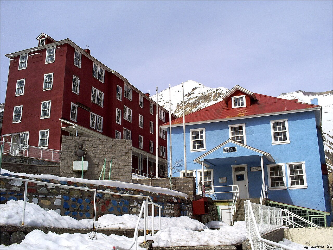 Colourful buildings of Sewell, the historic mining camp of the El Teniente copper mine, in snow below Andes peaks in Chile