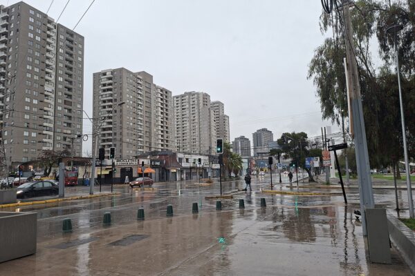 Rain falls on a wet street lined with apartment towers in Santiago, Chile
