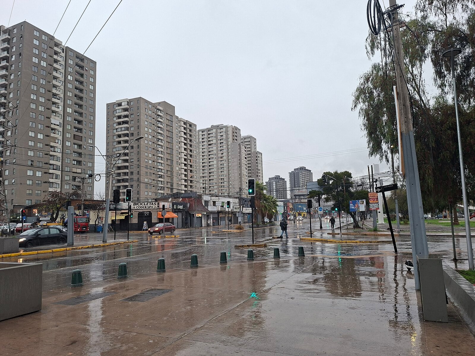Rain falls on a wet street lined with apartment towers in Santiago, Chile