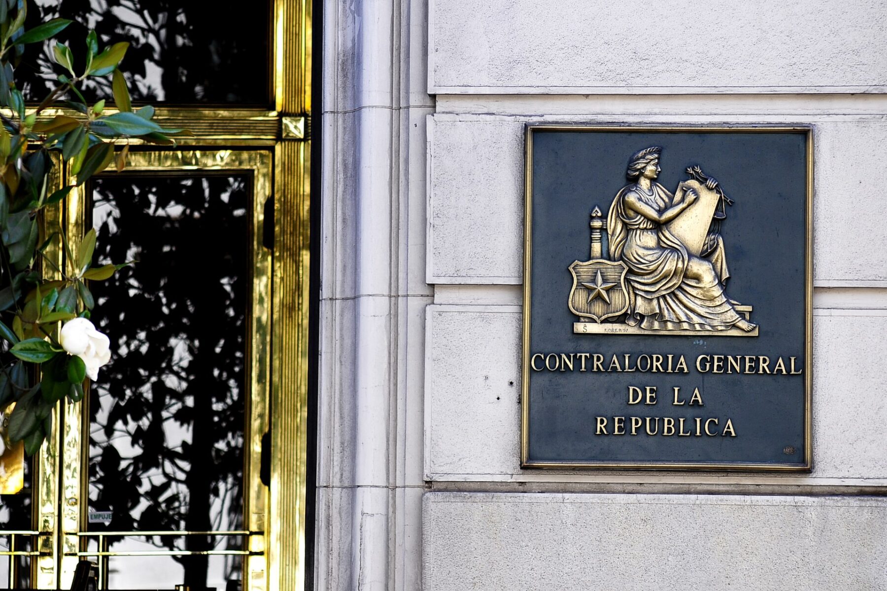 Brass plaque reading Contraloría General de la República beside the entrance of the comptroller's building in Santiago, Chile