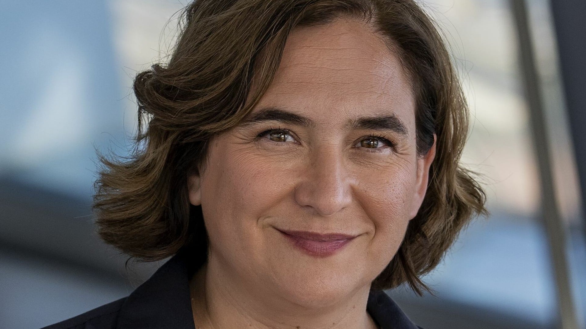 Ada Colau, leader of Spain's Frente Amplio alliance, smiling in a dark jacket