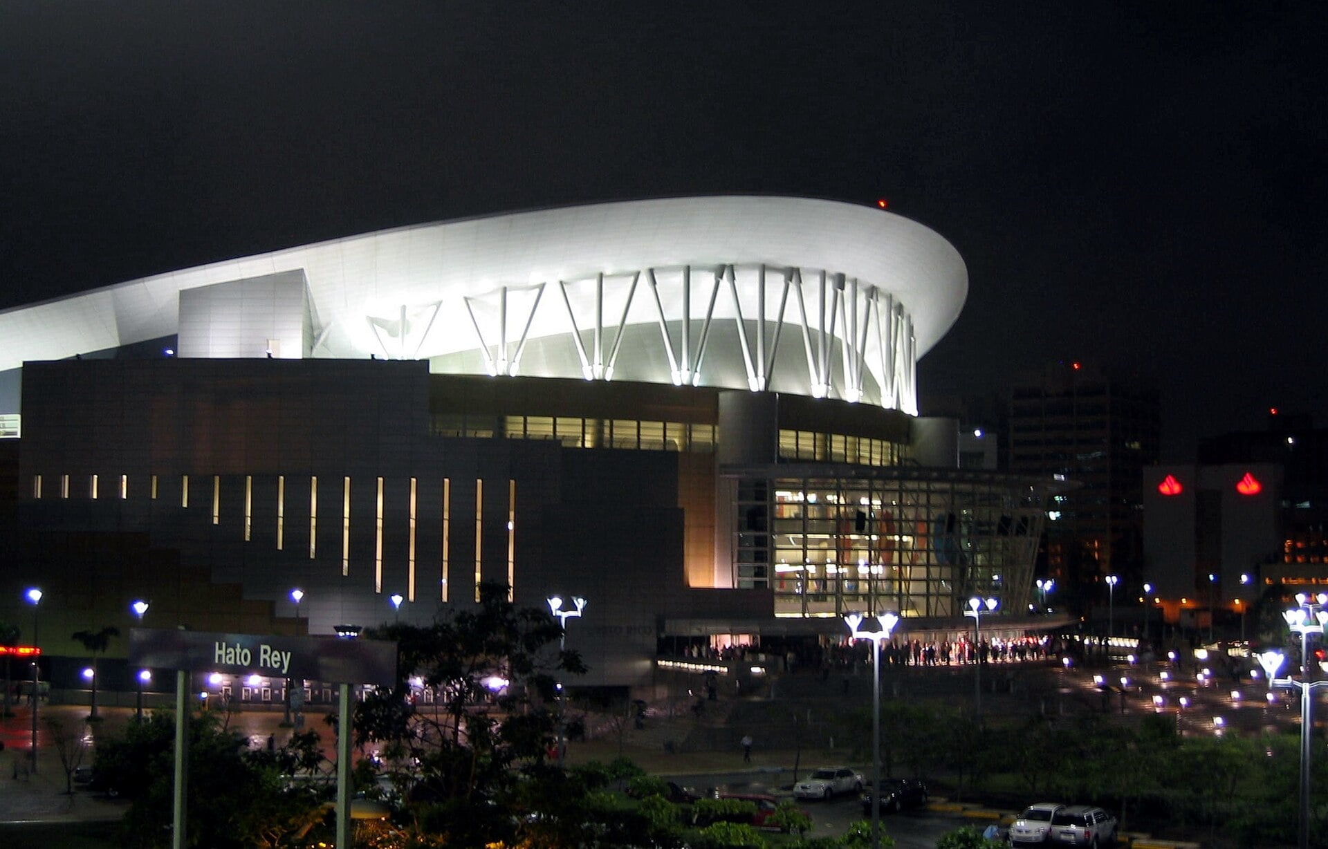 The Coliseo de Puerto Rico lit up at night beside a Hato Rey station sign