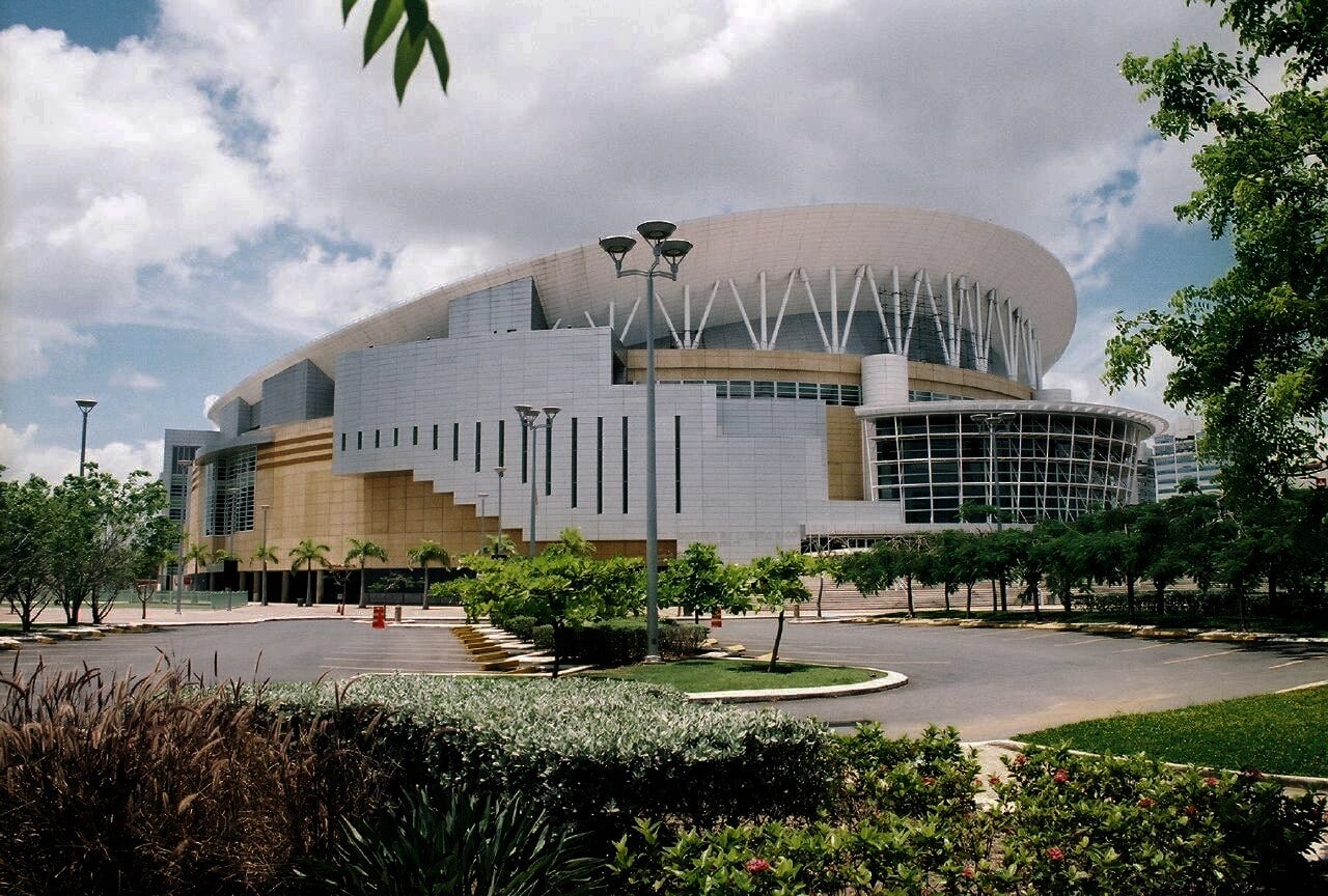 Exterior of the Coliseo de Puerto Rico arena in San Juan, with its curved white roof, on a sunny day