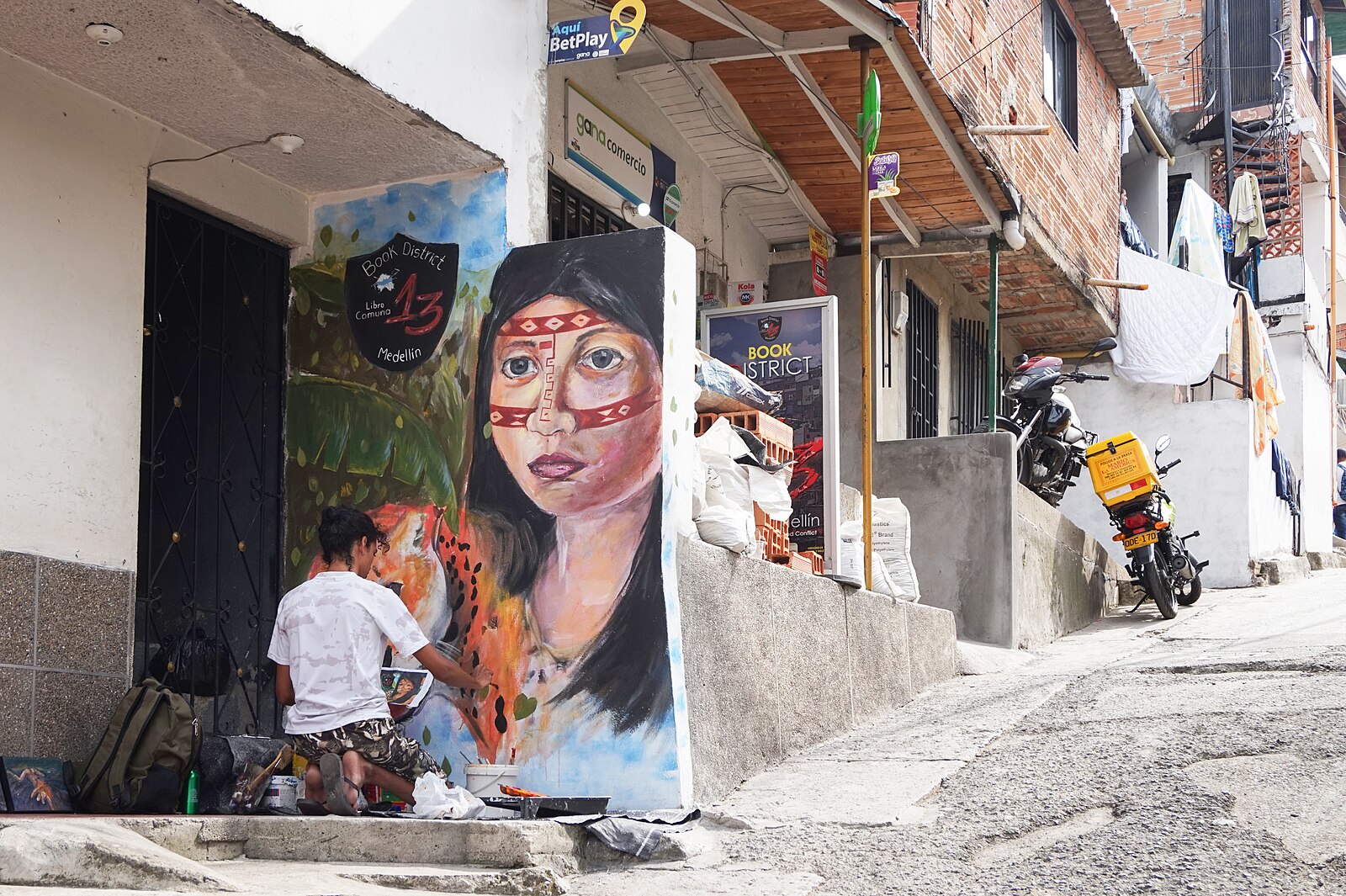 A street artist paints a mural of an Indigenous woman in Comuna 13, Medellin, part of Colombia culture