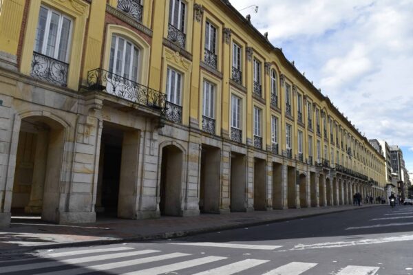 Yellow colonial-style arcaded building with iron balconies on a street in central Bogotá, Colombia